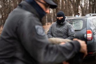 Polițist de frontieră român refuzând o mită oferită de un cetățean albanez la punctul de trecere Stamora-Moravița