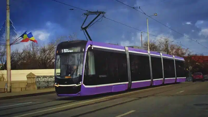 Tramvai modern în Timișoara și afiș cu noile rute temporare de autobuz valabile în perioada lucrărilor din Piața Traian.