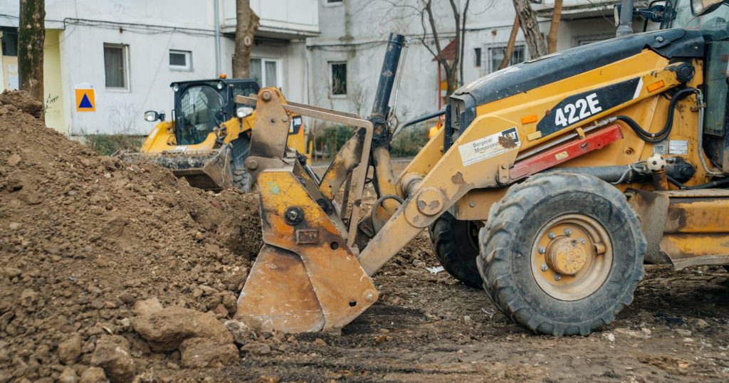 Utilaje și echipe de lucru care asfaltează noi locuri de parcare în cartierele Lipovei și Dâmbovița, pe locul fostelor garaje.