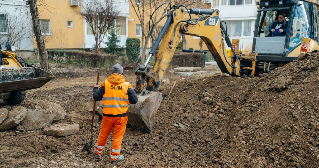 Utilaje și echipe de lucru care asfaltează noi locuri de parcare în cartierele Lipovei și Dâmbovița, pe locul fostelor garaje.