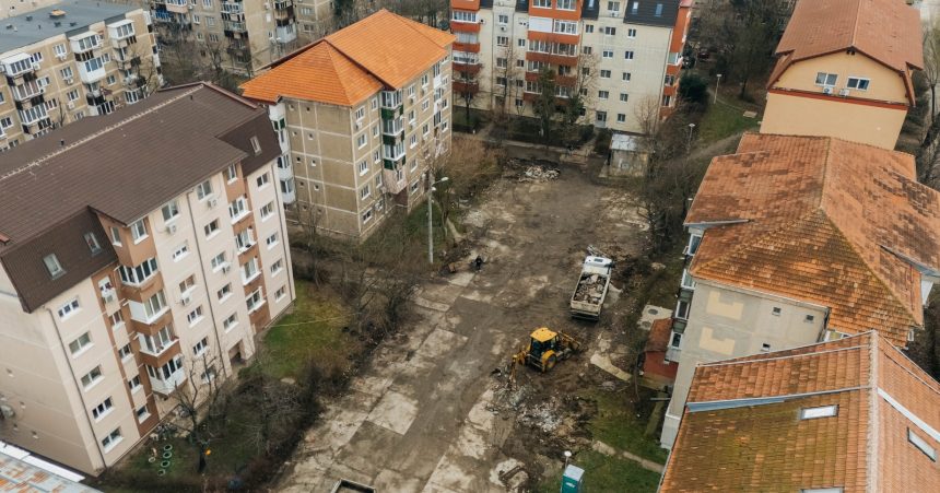 Utilaje și echipe de lucru care asfaltează noi locuri de parcare în cartierele Lipovei și Dâmbovița, pe locul fostelor garaje.