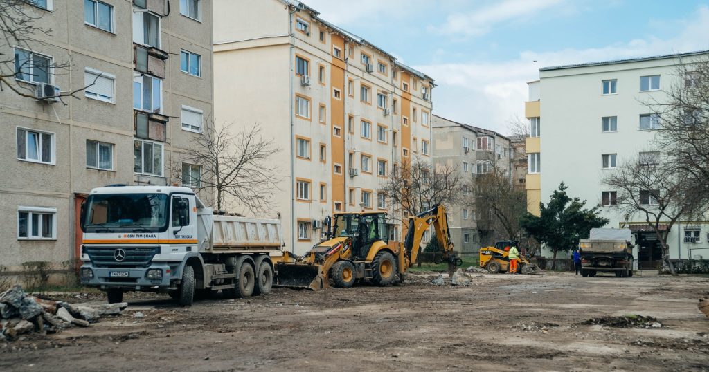 Utilaje și echipe de lucru care asfaltează noi locuri de parcare în cartierele Lipovei și Dâmbovița, pe locul fostelor garaje.