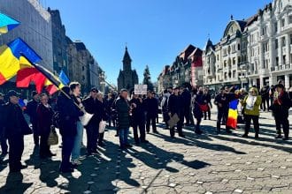 Oameni adunați în stradă în Timișoara, protestând pașnic împotriva măsurilor guvernamentale și cerând demisia premierului Ilie Bolojan.