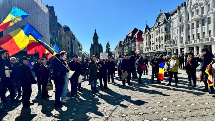 Oameni adunați în stradă în Timișoara, protestând pașnic împotriva măsurilor guvernamentale și cerând demisia premierului Ilie Bolojan.