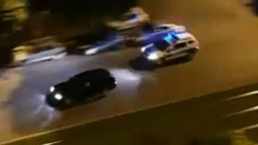 Mașină de poliție cu semnalele luminoase aprinse în urmărirea unui autoturism pe o șosea