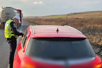 Polițist rutier din cadrul IPJ Timiș oprind un autoturism pentru control pe DN 6 în timpul unei acțiuni de prevenire a accidentelor rutiere
