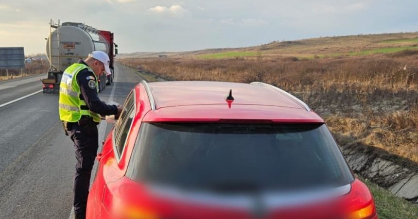 Polițist rutier din cadrul IPJ Timiș oprind un autoturism pentru control pe DN 6 în timpul unei acțiuni de prevenire a accidentelor rutiere