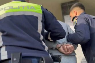 Imagine cu un bărbat condus de polițiști spre audieri după ce a fost prins conducând fără permis în localitatea Grabaț