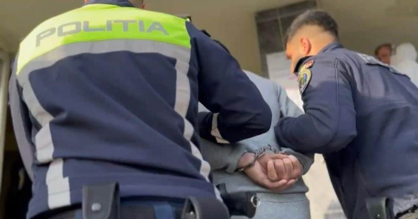 Imagine cu un bărbat condus de polițiști spre audieri după ce a fost prins conducând fără permis în localitatea Grabaț