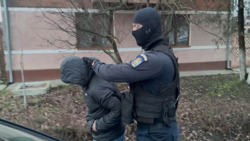 Mascați și anchetatori în fața unei locuințe în timpul descinderilor DIICOT din județul Timiș