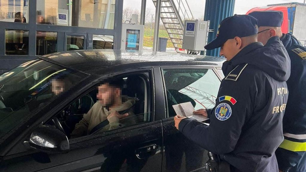 Ofițer de poliție de frontieră utilizând noul scaner facial și de amprente pentru procesarea unui profil digital EES.