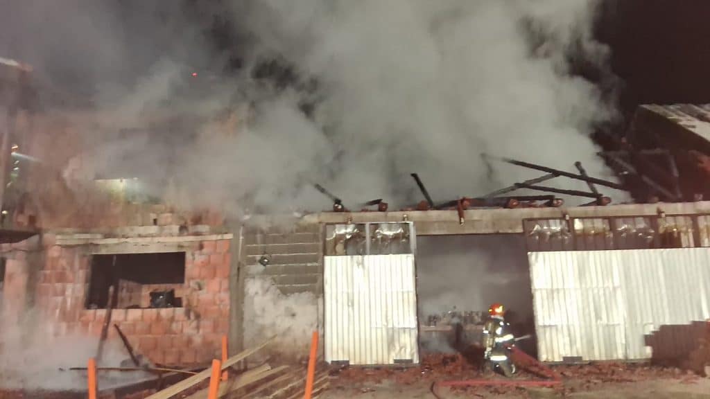 Autospeciale de stingere ale ISU Hunedoara acționând pe timp de noapte pentru lichidarea incendiului de la gaterul din Romos.