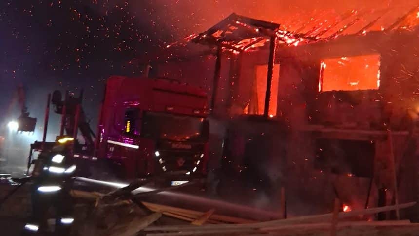Autospeciale de stingere ale ISU Hunedoara acționând pe timp de noapte pentru lichidarea incendiului de la gaterul din Romos.