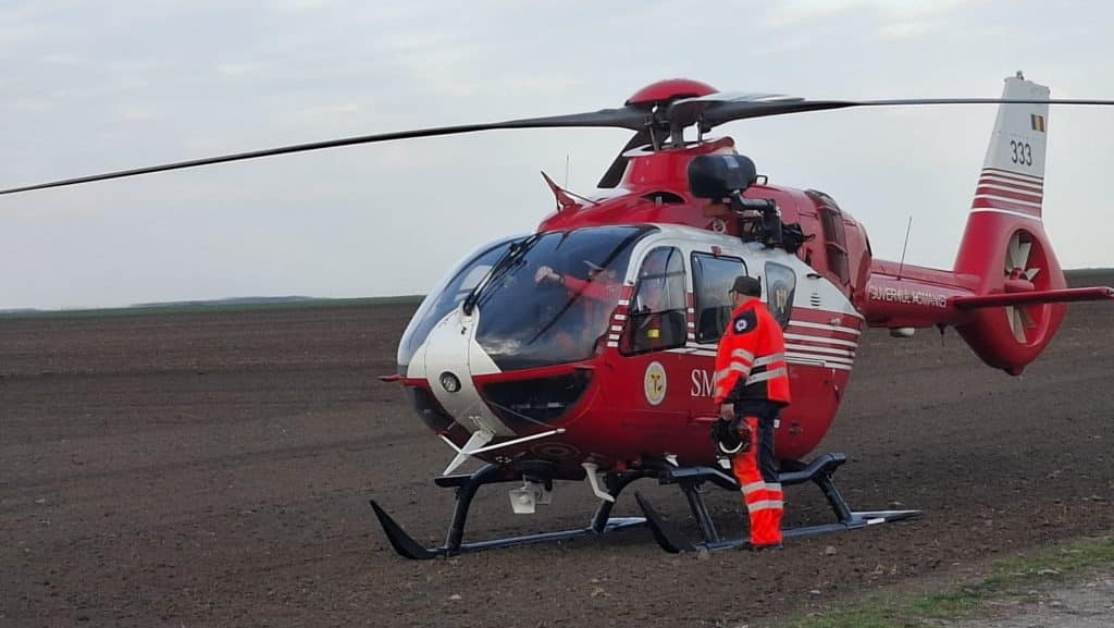 Elicopter SMURD aterizat pe carosabilul autostrăzii A1, lângă un autoturism cu platformă grav avariat în urma impactului cu un TIR.