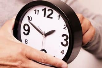 Ilustrație cu un ceas analogic fiind dat înainte cu o oră pentru trecerea la ora de vară 2026 în România