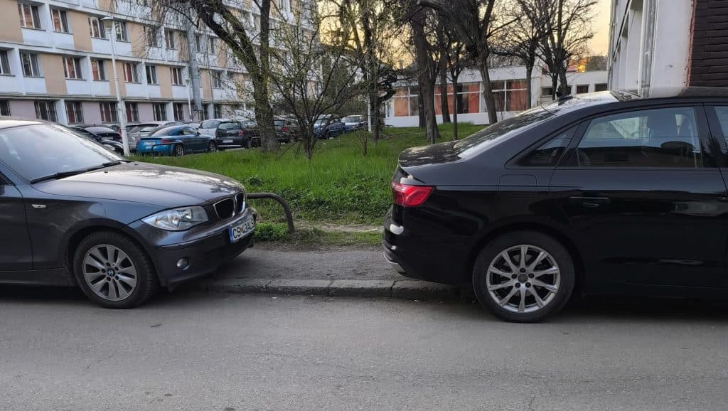 Imagine surprinzând mașini parcate ilegal pe un trotuar îngust din Timișoara, blocând complet accesul pietonilor și al cărucioarelor.