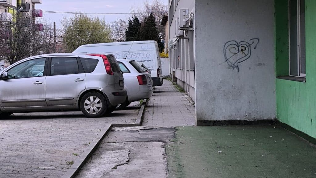 Imagine surprinzând mașini parcate ilegal pe un trotuar îngust din Timișoara, blocând complet accesul pietonilor și al cărucioarelor.