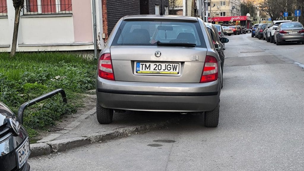 Imagine surprinzând mașini parcate ilegal pe un trotuar îngust din Timișoara, blocând complet accesul pietonilor și al cărucioarelor.