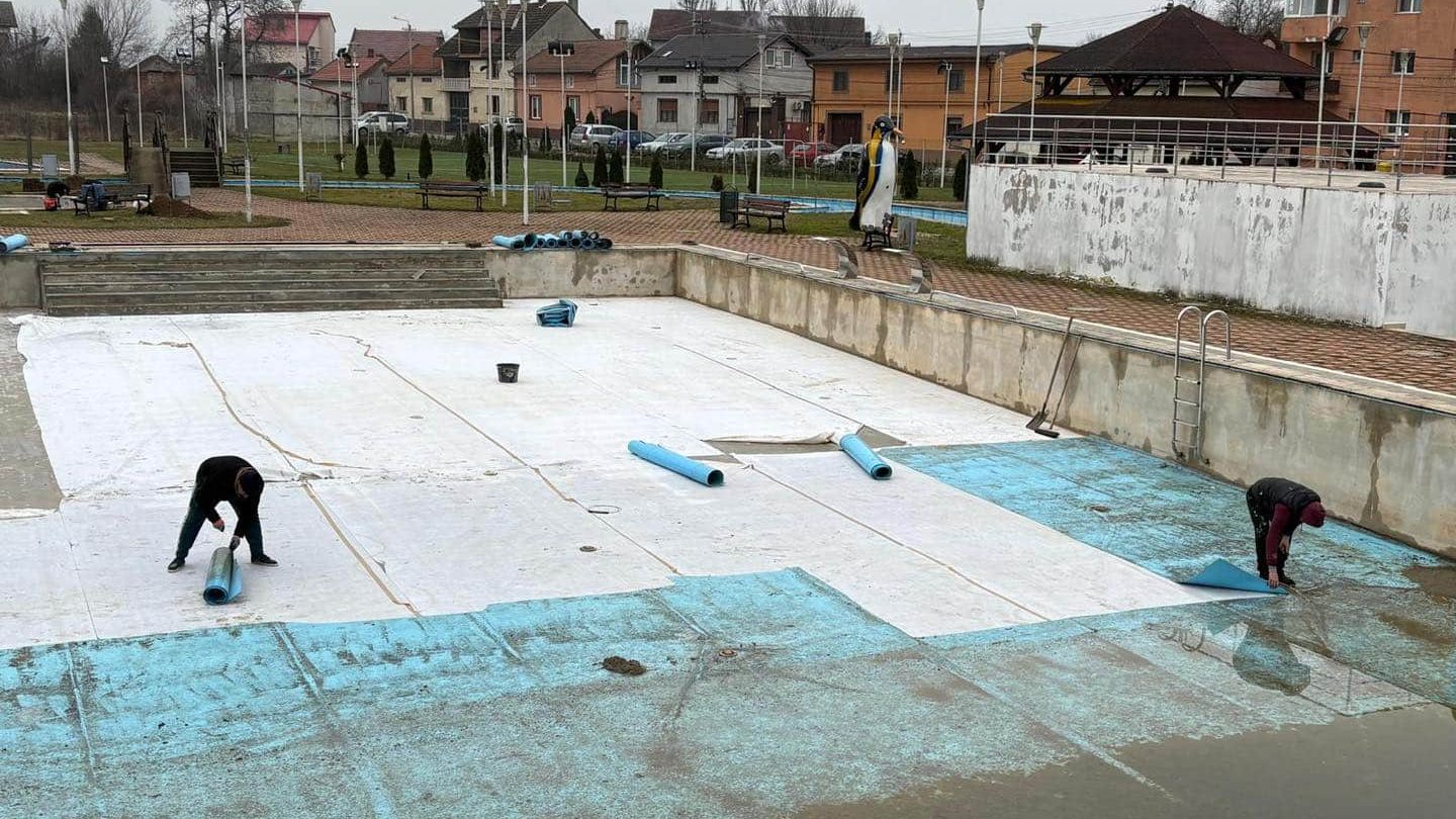 Echipe de muncitori lucrând la refacerea instalațiilor distruse de la ștrandul municipal din Lugoj.