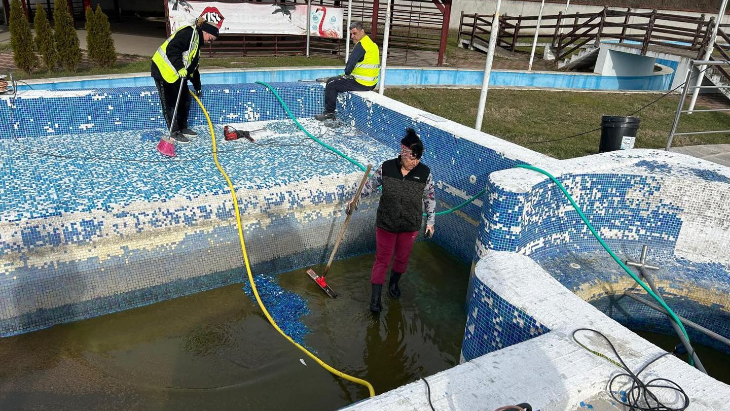 Echipe de muncitori lucrând la refacerea instalațiilor distruse de la ștrandul municipal din Lugoj.