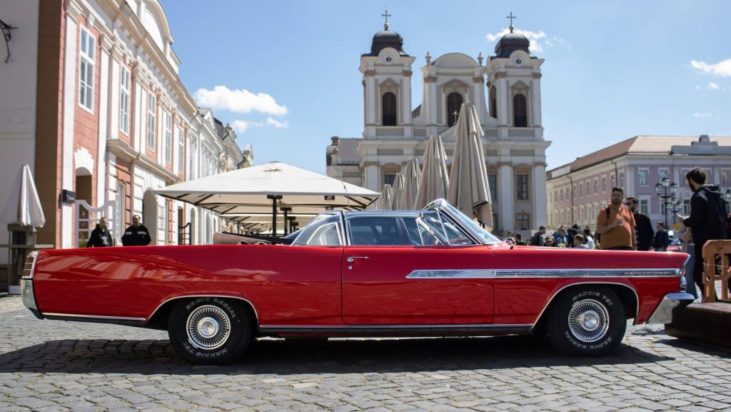 Expoziție de mașini clasice și vehicule istorice de colecție aliniate în fața Domului Romano-Catolic din Piața Unirii, Timișoara.