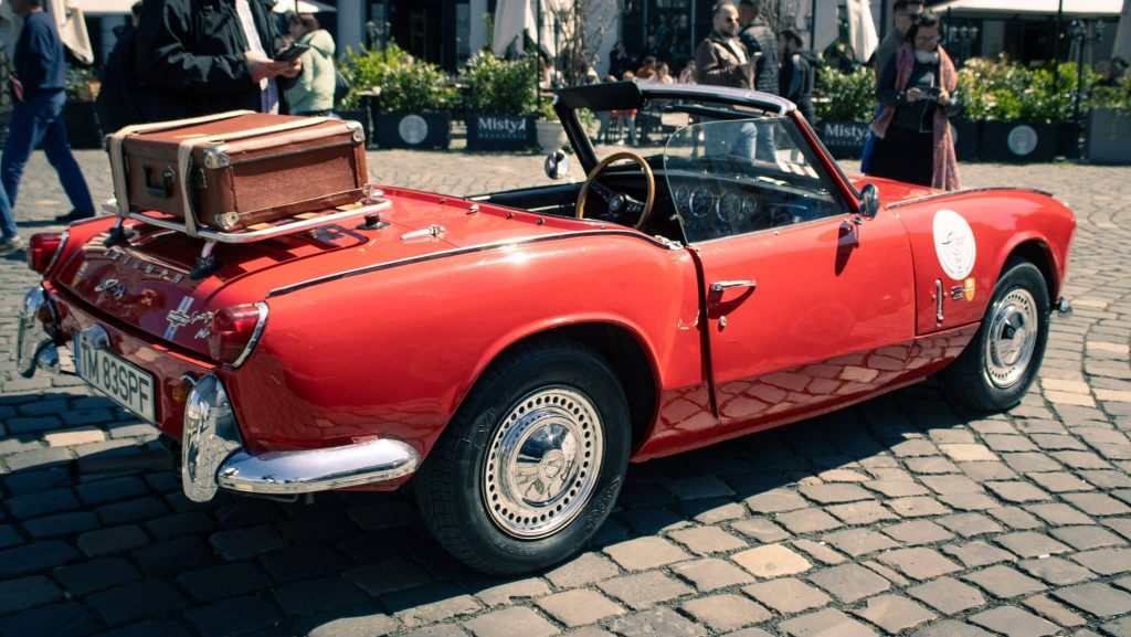 Expoziție de mașini clasice și vehicule istorice de colecție aliniate în fața Domului Romano-Catolic din Piața Unirii, Timișoara.