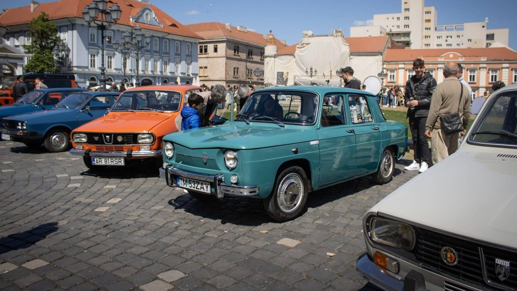 Expoziție de mașini clasice și vehicule istorice de colecție aliniate în fața Domului Romano-Catolic din Piața Unirii, Timișoara.