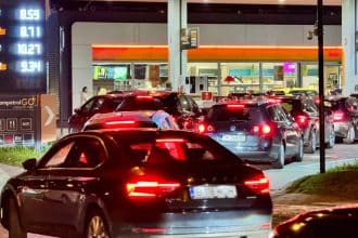 Zeci de mașini așteptând la rând la o stație de alimentare Rompetrol din Timișoara pentru a profita de ieftinirea benzinei.