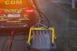 Utilaje de curățenie intervenind noaptea pe carosabilul DJ 691 în Dumbrăvița pentru eliminarea prafului și noroiului.