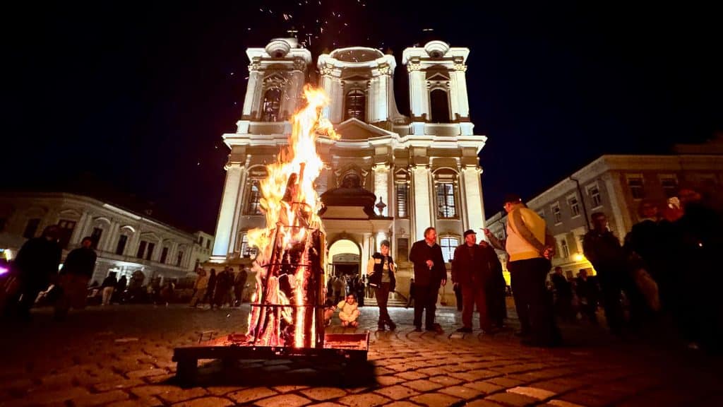 Credincioși catolici cu lumânări aprinse la Vigilia Pascală în Domul din Timișoara, primind Lumina Învierii în Piața Unirii