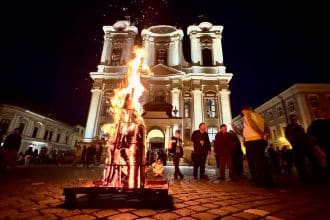 Credincioși catolici cu lumânări aprinse la Vigilia Pascală în Domul din Timișoara, primind Lumina Învierii în Piața Unirii