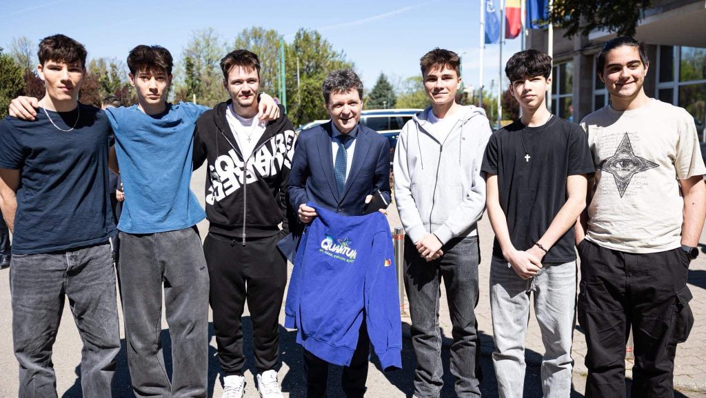 Președintele Nicușor Dan purtând bluza personalizată primită de la tinerii din Lotul Național de Robotică la Universitatea de Vest din Timișoara.