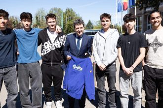 Președintele Nicușor Dan purtând bluza personalizată primită de la tinerii din Lotul Național de Robotică la Universitatea de Vest din Timișoara.