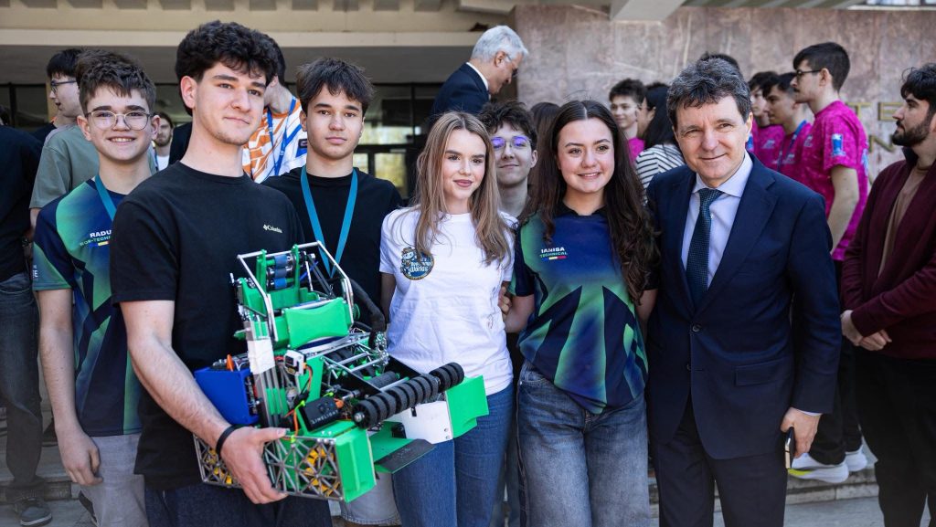 Președintele Nicușor Dan purtând bluza personalizată primită de la tinerii din Lotul Național de Robotică la Universitatea de Vest din Timișoara.