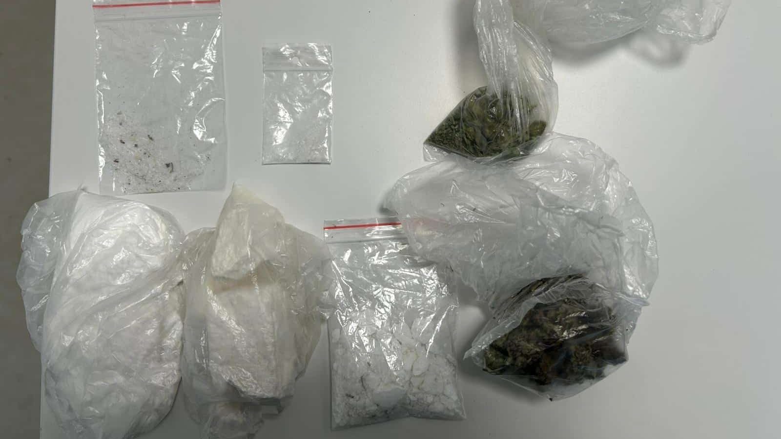 Probe ridicate de polițiști în urma unor percheziții: plicuri cu substanță albă (cocaină), cântare electronice și teancuri de bani.