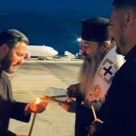 Preoți și reprezentanți ai eparhiilor din vestul țării preluând Lumina Sfântă în felinare speciale de pe pista Aeroportului Internațional Timișoara.