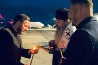 Preoți și reprezentanți ai eparhiilor din vestul țării preluând Lumina Sfântă în felinare speciale de pe pista Aeroportului Internațional Timișoara.