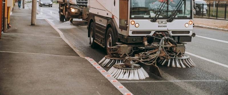 Utilaj modern al operatorului SaluT efectuând curățenia carosabilului până la bordură într-un cartier din Timișoara.