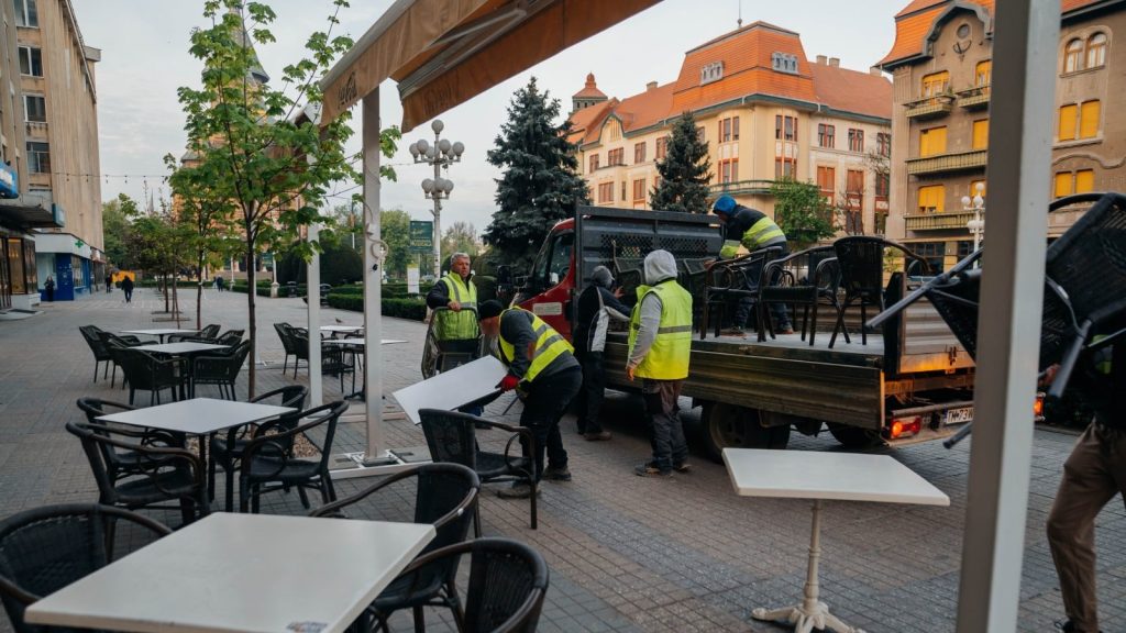Echipele municipalității ridicând scaunele și mesele unei terase neautorizate din centrul Timișoarei.