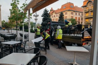 Echipele municipalității ridicând scaunele și mesele unei terase neautorizate din centrul Timișoarei.