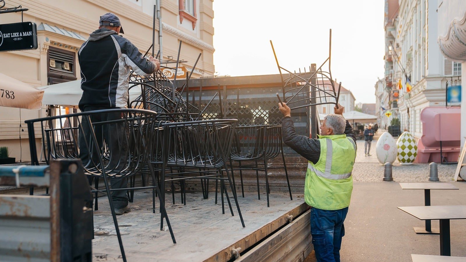 Echipele municipalității ridicând scaunele și mesele unei terase neautorizate din centrul Timișoarei.