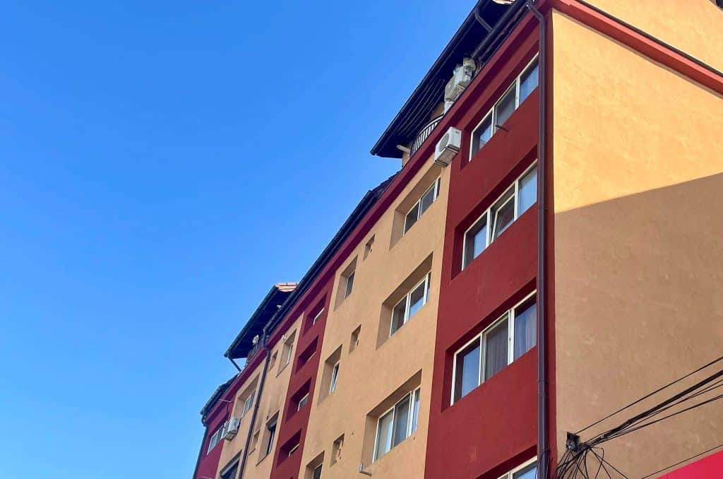 Infografic comparativ al prețurilor pe metru pătrat în Timișoara, Cluj și Brașov pentru apartamente noi și vechi în aprilie 2026.