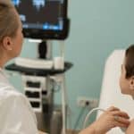 Medic pediatru examinând un copil cu dificultăți respiratorii la Clinica II Bega din Timișoara în timpul sezonului de polen.