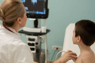 Medic pediatru examinând un copil cu dificultăți respiratorii la Clinica II Bega din Timișoara în timpul sezonului de polen.