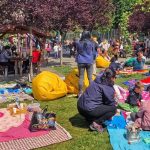 Copii și părinți participând la ateliere creative și spectacole de teatru în aer liber în Parcul Steaua din Timișoara.