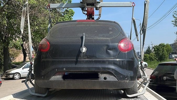Echipaj Timpark ridicând un autovehicul declarat abandonat de pe o stradă din Timișoara.