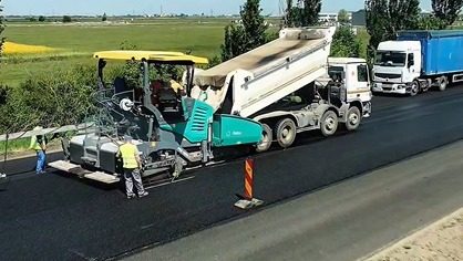 Utilaje de asfaltare și muncitori lucrând la fundația drumului pe Calea Șagului în timpul minivacanței.