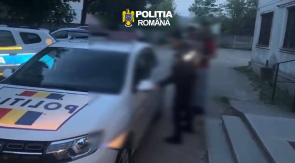 Polițiști în misiune efectuând identificarea unei persoane urmărite internațional într-un local.
