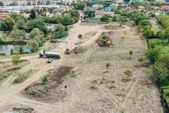 Utilaje de mare tonaj curățând tone de gunoi de pe terenul de lângă Lacul Balaurul din Timișoara.