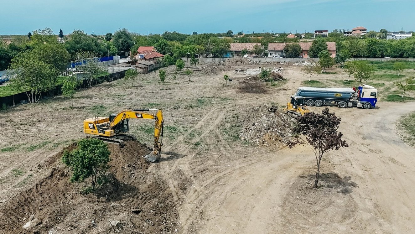 Utilaje de mare tonaj curățând tone de gunoi de pe terenul de lângă Lacul Balaurul din Timișoara.
